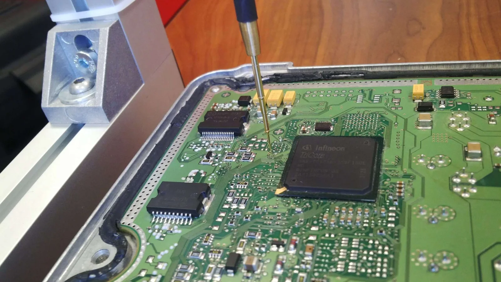 Technician probing a vehicle ECU during a programming session