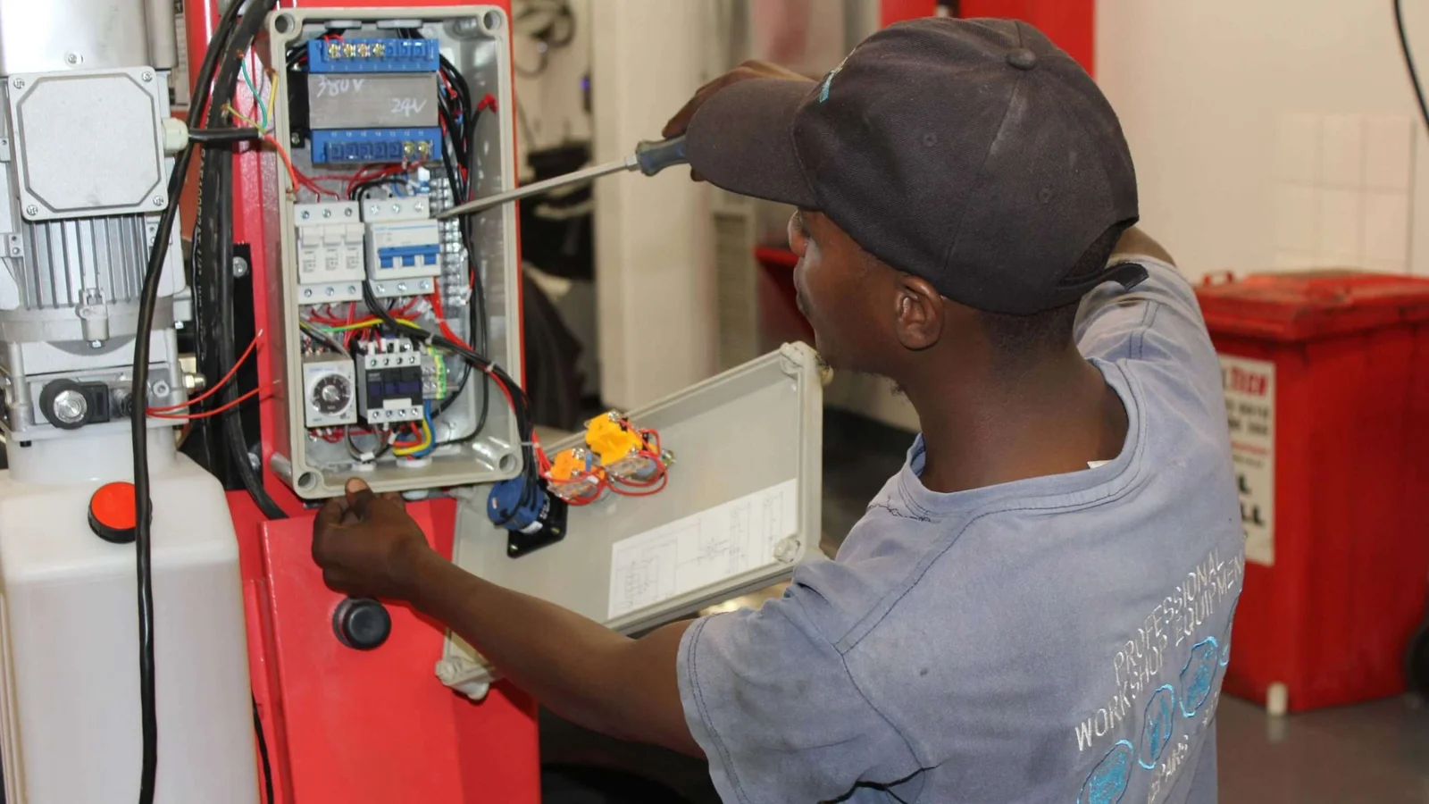Technician commissioning the electrical controls of a vehicle lift